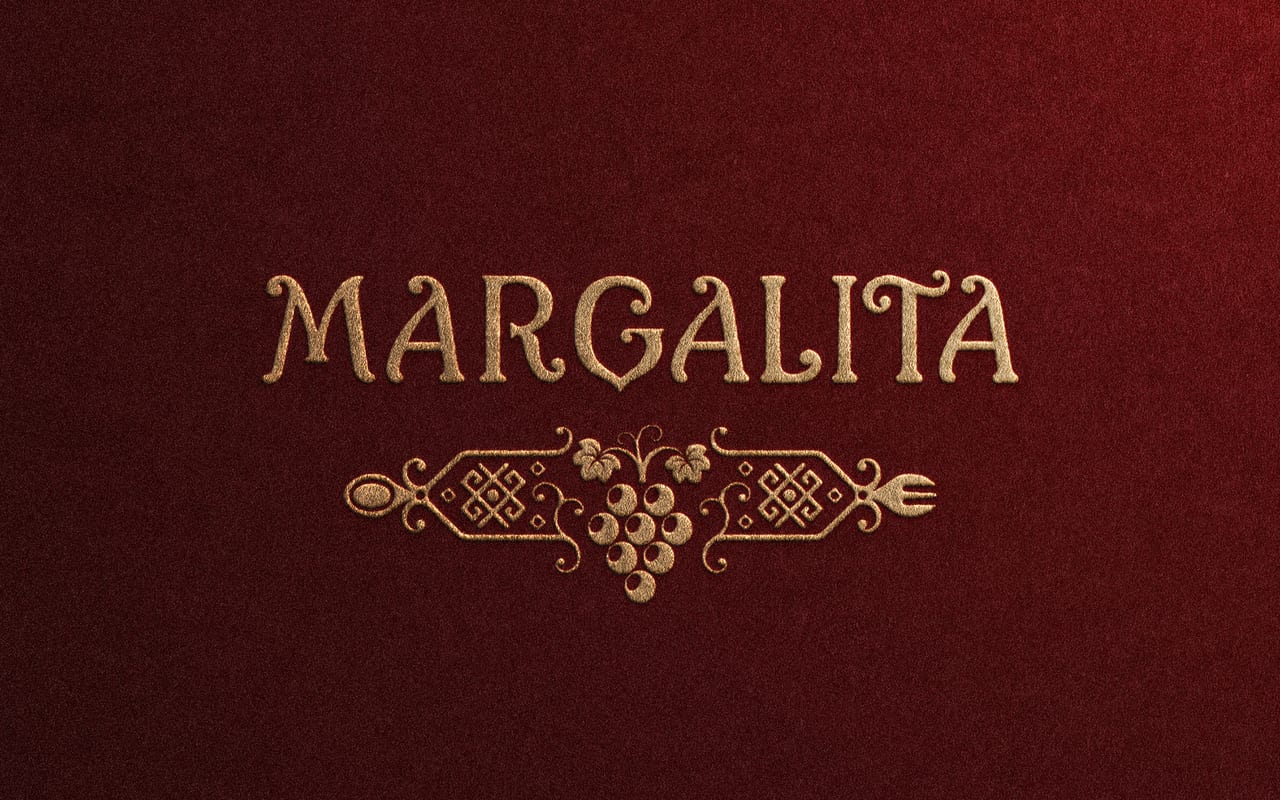 Margalita’s gold wordmark and ornamental grape motif on a burgundy background